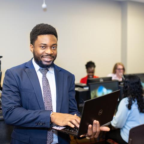 Student in suit with laptop