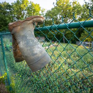 Pair of rubber boots hangning on a fence